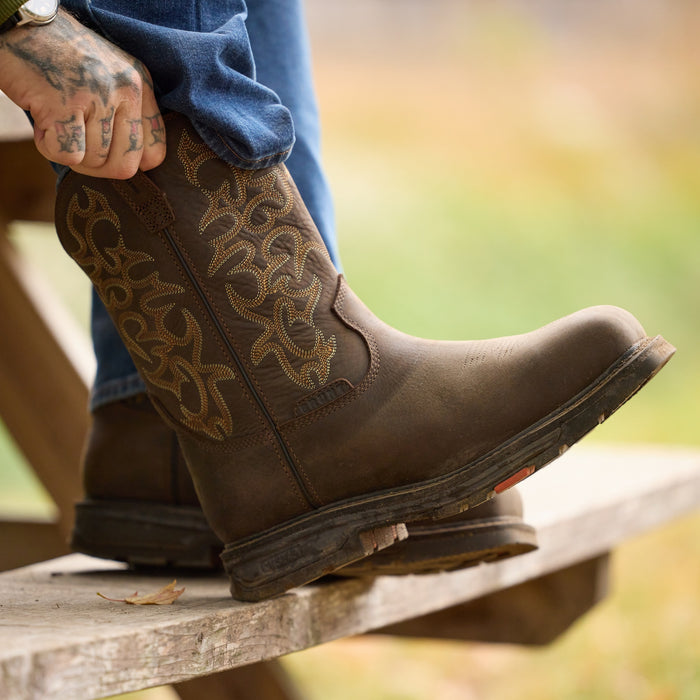 Man putting on BRUNT 10 inch welted composite square toe work boot in dark brown
