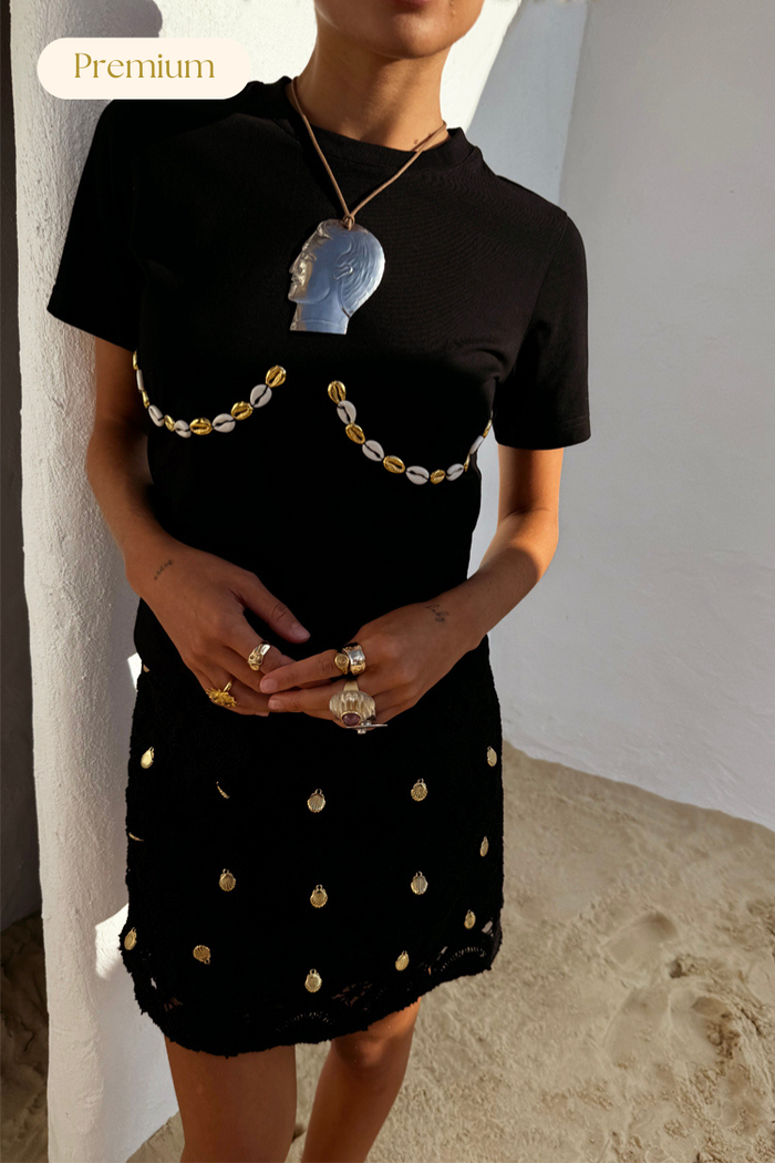 Black Crochet Shell Wrap Skirt with gold shell details and matching t-shirt, styled for a premium vacation look.