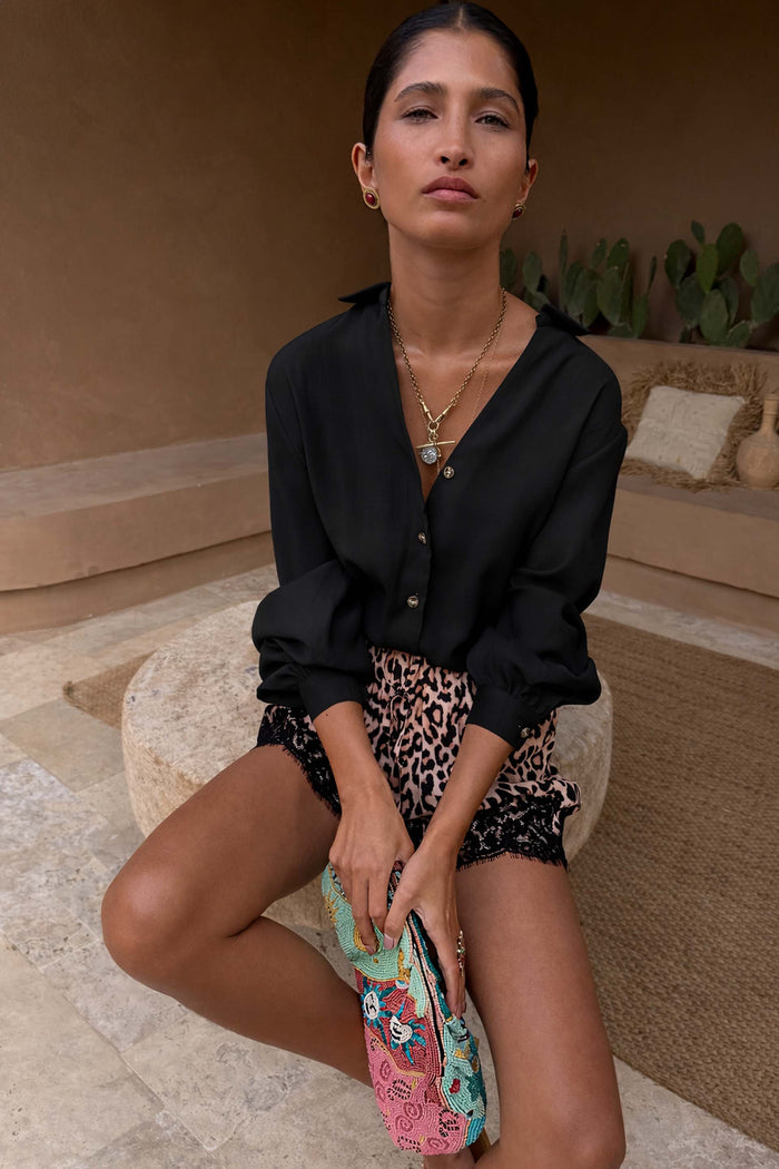 Black Miley Shirt with blouson sleeves and tortoise buttons, styled with leopard print lace shorts.