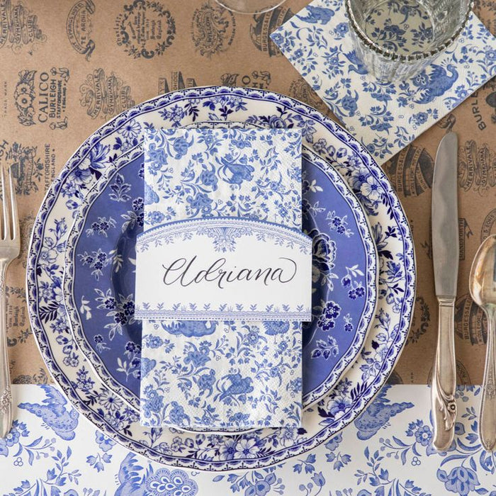Blue and white patterned table setting with a name card on a rustic background