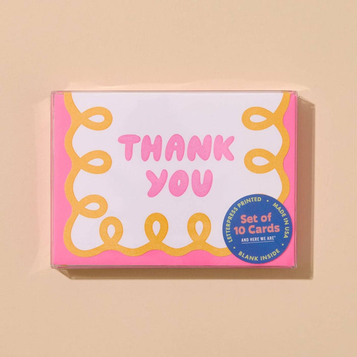 Box of 'Thank You' cards with pink text and decorative elements on a beige background