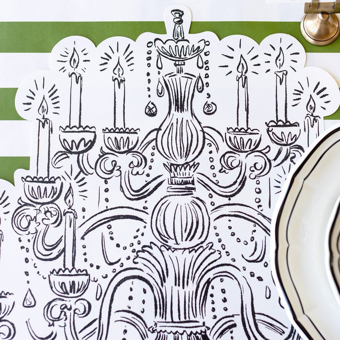 Decorative tablecloth with intricate black and white design featuring candles and a vase on a green and white striped background.