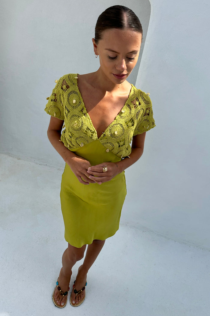 Green Shell Mini Elodie Dress in lime featuring a crochet knit bodice with gold charms and a satin mini skirt.