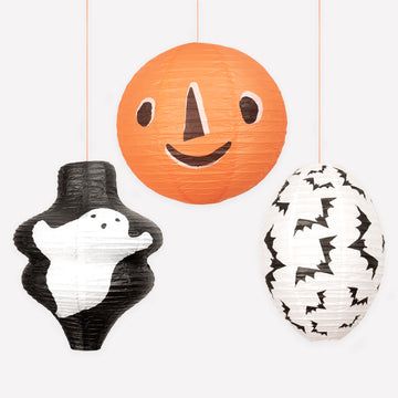 Three Halloween-themed paper lanterns hanging against a white background.