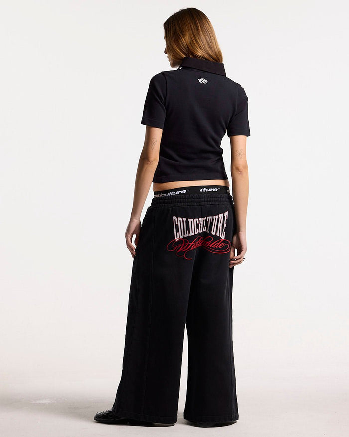 NIA SET POLO BLACK - black graphic print polo shirt, back view on female model - Cold Culture #woman