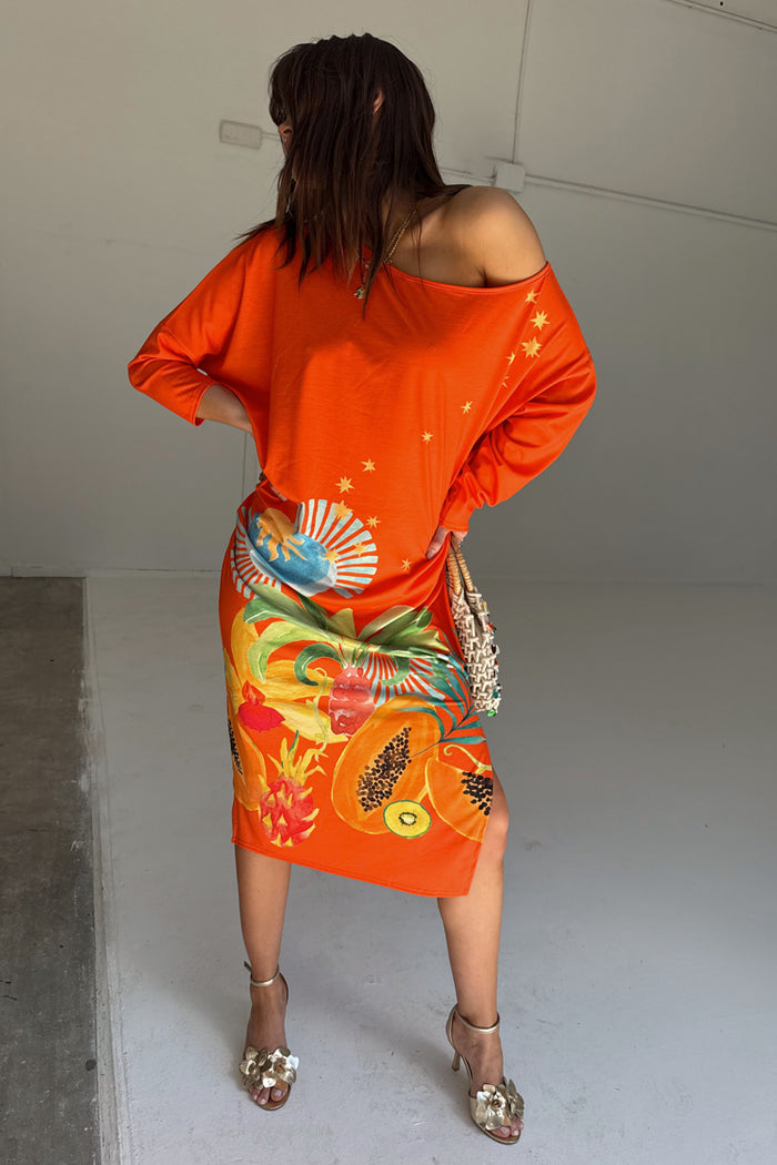 Orange Rio Jem Dress with a tropical fruit print and sun motifs in a relaxed, off-the-shoulder midi silhouette.