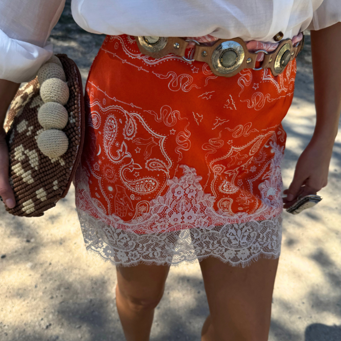 Red Bandana Maeva Skirt featuring an iconic print and white lace trim, styled with a decorative belt.