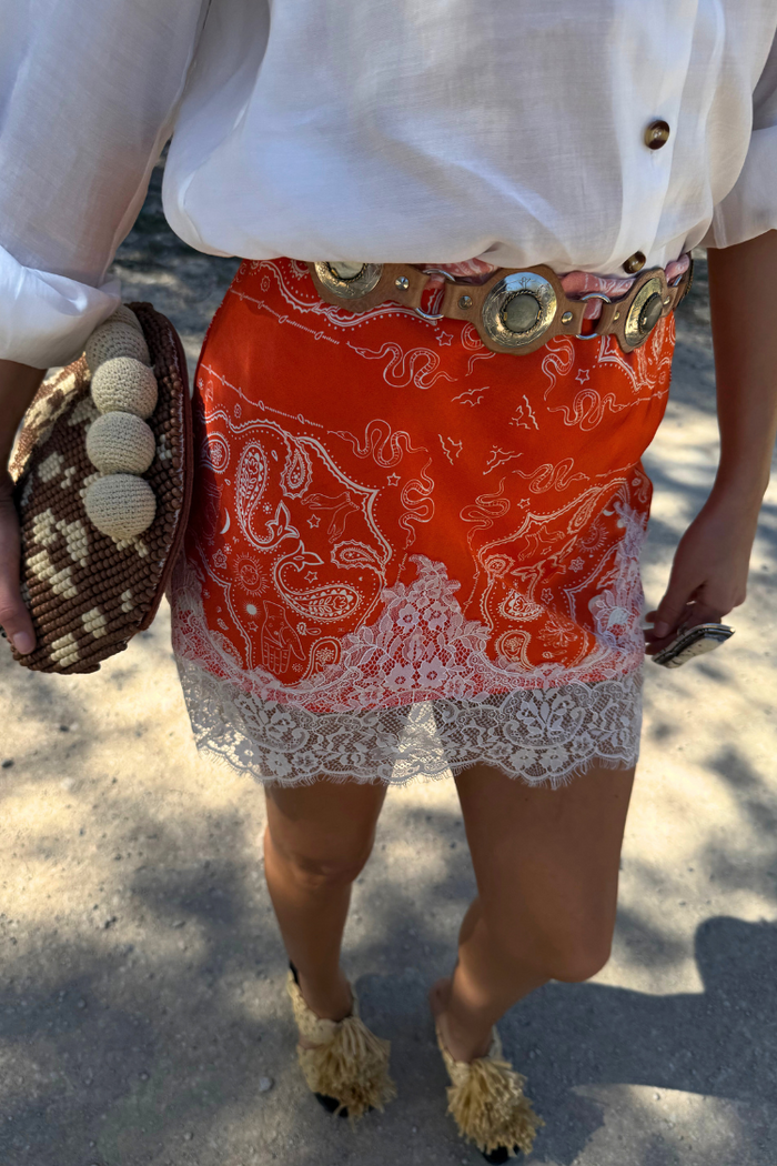 Red Bandana Maeva mini skirt featuring an iconic print and white lace border, styled with a white shirt.