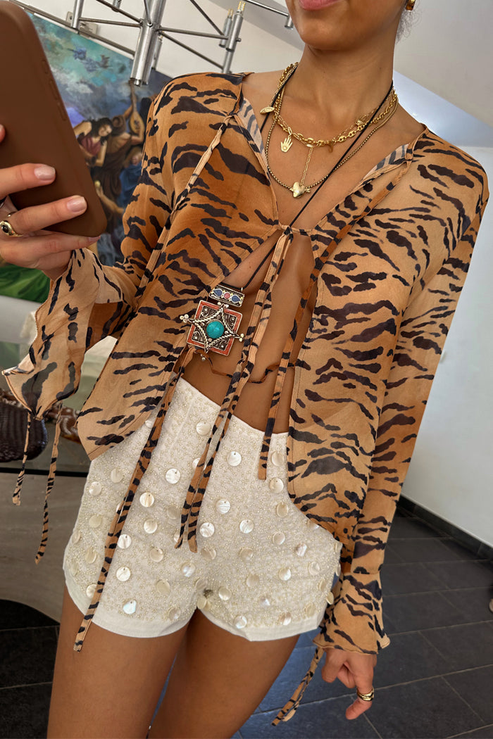 Cream beaded Shells Hot Pants with pearlescent shell details, styled with a sheer tiger print tie-front top.