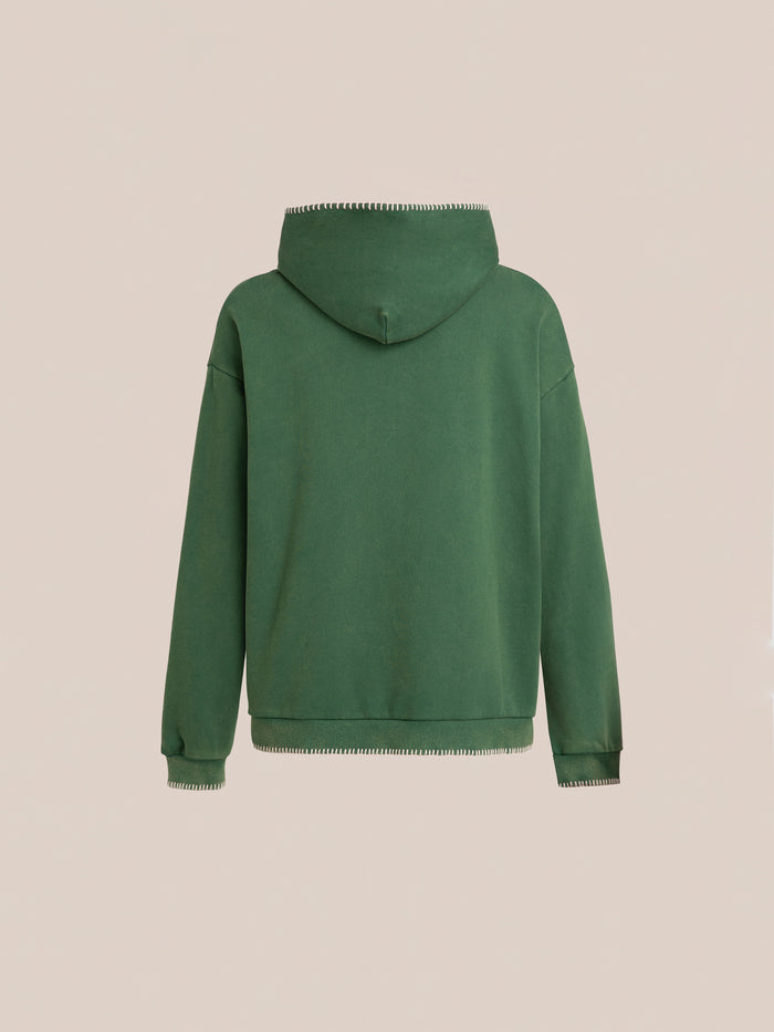 The FOUND Stitched Border Distressed Logo Hoodie, an oversized vintage piece in plain green french terry cotton, is shown from the back against a beige background.
