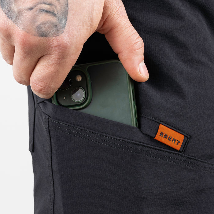 Putting phone in tech pocket of BRUNT 11 inch lightweight breathable costello work shorts in black