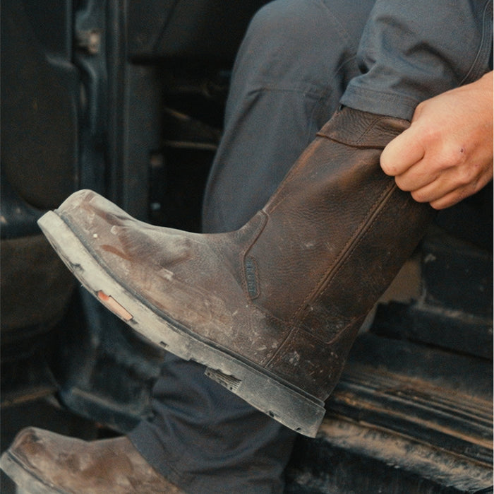Man pulling on BRUNT 10 inch waterproof soft toe pull-on boot in dark brown