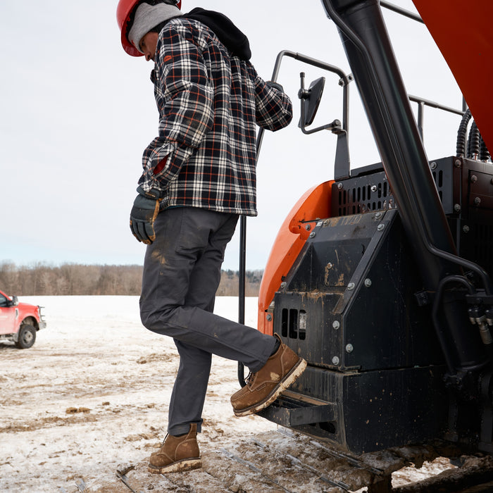 Man on jobsite wearing the BRUNT water resistant stretch torra work pant in charcoal