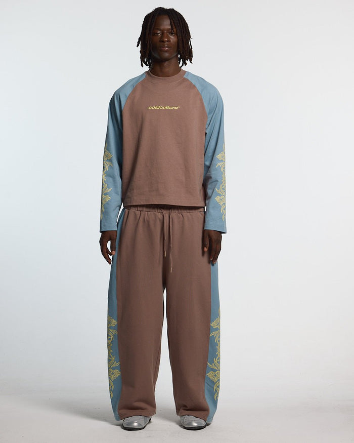 TRIBAL SWEATPANTS BROWN & BLUE - brown and blue tribal sweatpants, front view on male model - Cold Culture #man