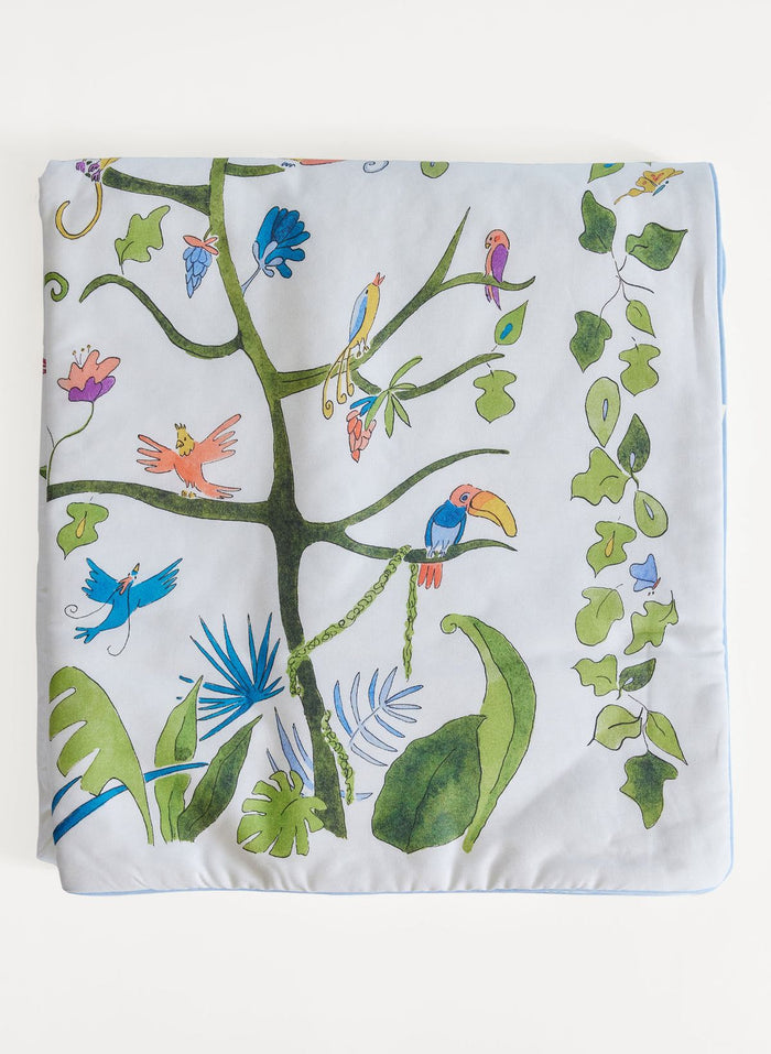 Decorative blanket with a colorful tree and birds design on a white background