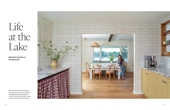 A magazine-style interior photo page with the headline 'Life at the Lake' and a photo of a woman standing in a bright kitchen and dining area. The page includes architectural text on the left and a large interior scene on the right showing patterned wallpaper, wood floors, counters, and a table with chairs.