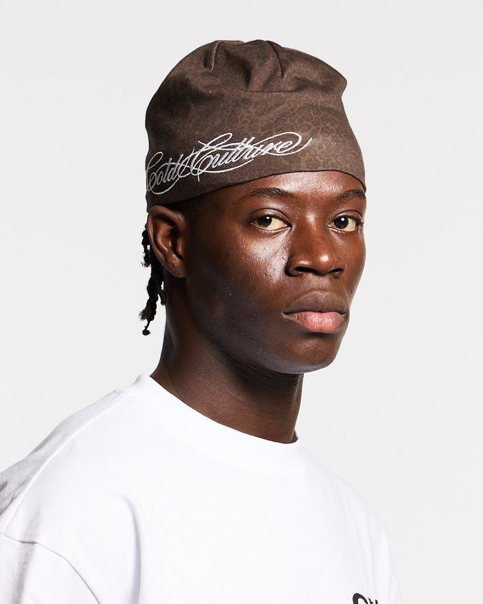 WILD SCRIPT BEANIE LEOPARD - brown leopard print beanie, on model close-up - Cold Culture #man